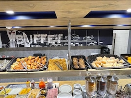 A buffet with various food items and condiments.
