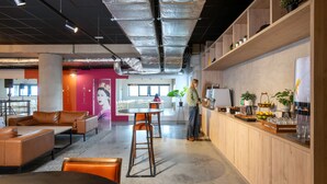 An open-plan office with a bar area, seating, and a large window. - Ibis Styles Namur (Namur)