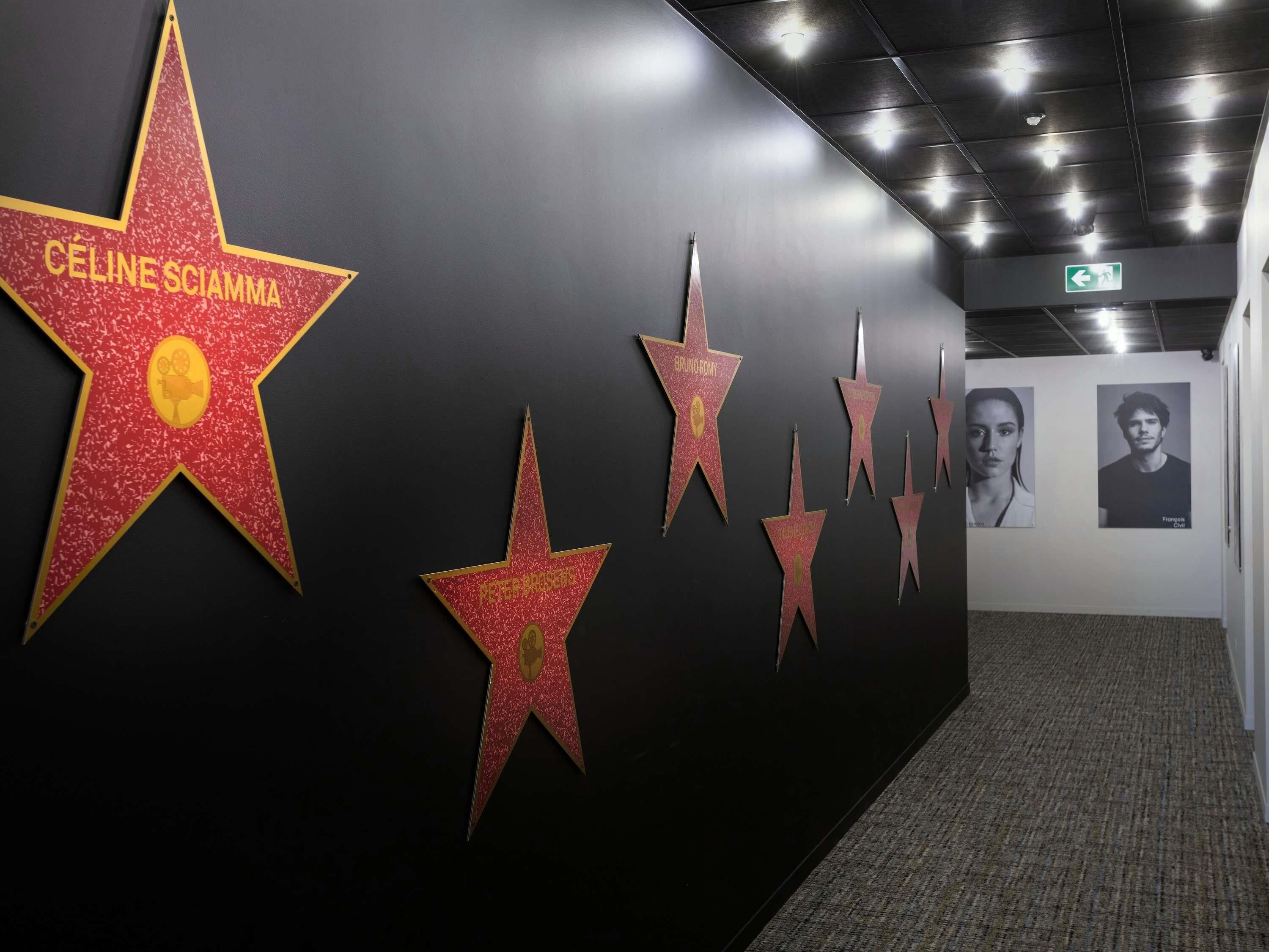 A hallway with a series of star-shaped decorations on the wall, each labeled with a name.