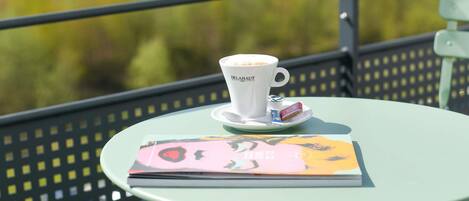 A table with a cup of coffee and a book on it.