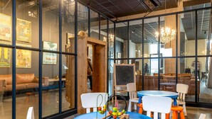 A modern interior with glass walls, wooden furniture, and a children's play area with a toy table. - Ibis Styles Namur (Namur)