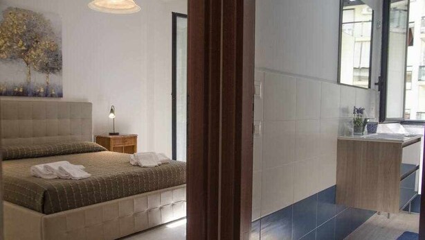 Een slaapkamer met een bed, nachtkastje en een bijpassend tafeltje.