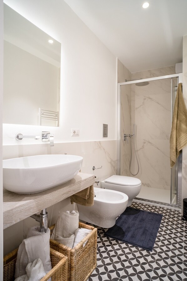 A modern bathroom with a large sink, toilet, and shower. - City View Apartment in Monopoli (Monopoli)