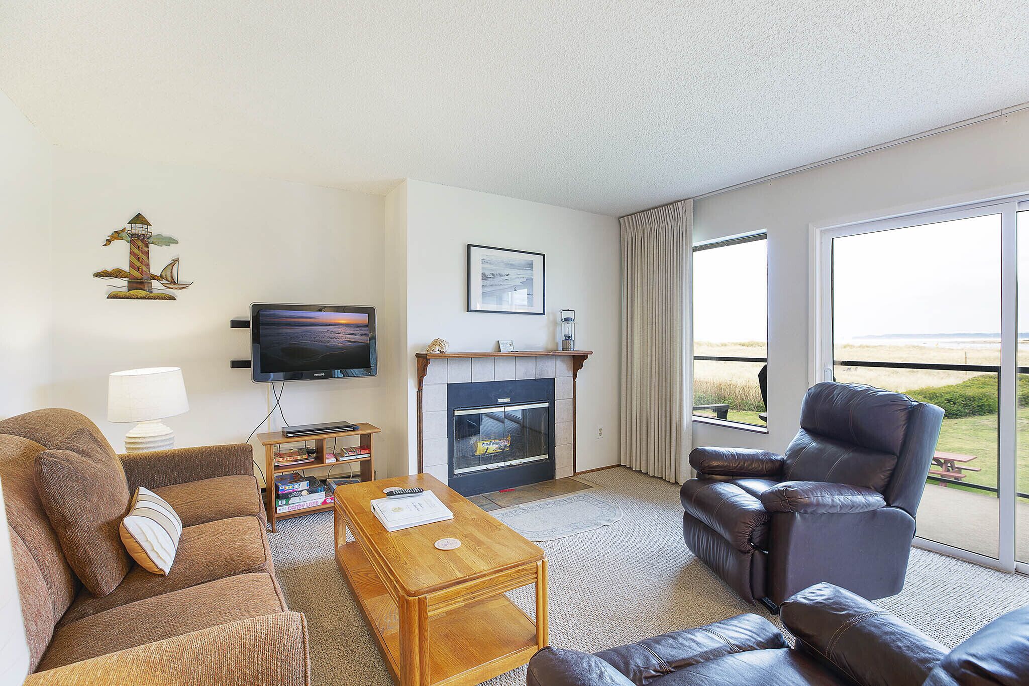 A living room with a fireplace, a television, a sofa, and a recliner.