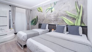 Een moderne hotelkamer met twee bedden, een groot raam met gordijnen, een badkuip en een muurschildering.