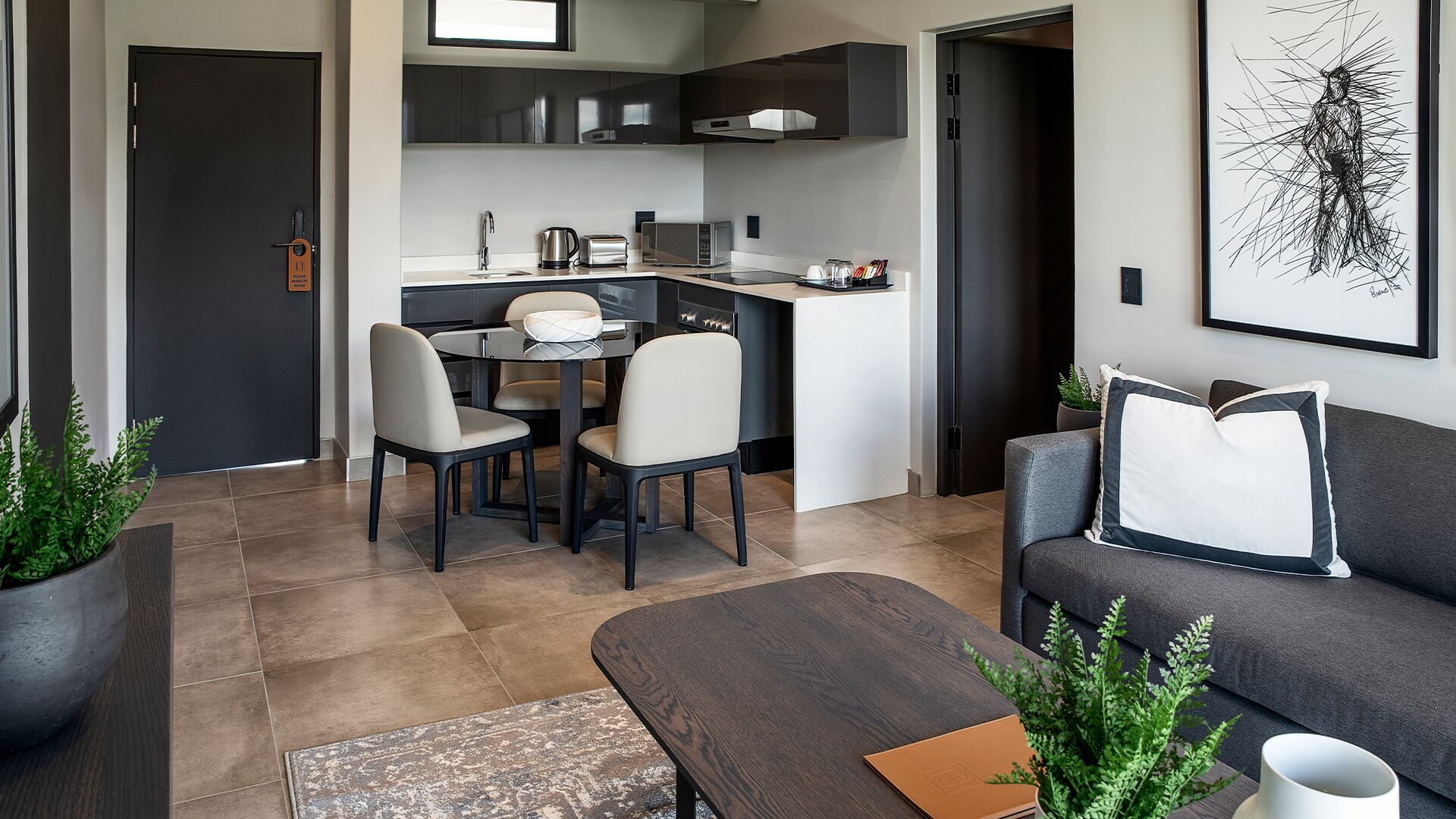 A modern apartment with a dining area, kitchenette, and a living room.