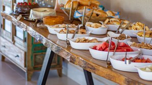 Una mesa de bufé con diferentes alimentos y una estatua decorativa.