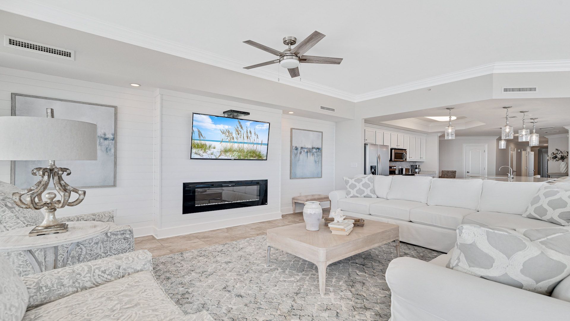 A spacious living room with a fireplace, a television, and a ceiling fan.