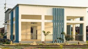 Een modern gebouw met een plat dak, grote ramen en een centrale verticale constructie.