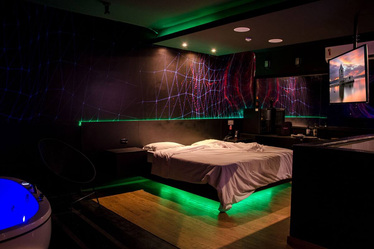 Une chambre moderne avec un lit, un bureau et un grand élément décoratif mural.
