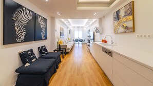 A modern living room with a sofa, a dining area, and a kitchen. - D9 center of Glyfada (Glyfada)