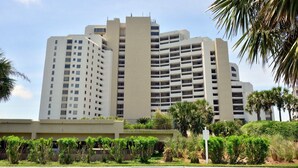 Un hôtel à plusieurs étages doté d’une architecture moderne, avec des balcons et un toit plat.