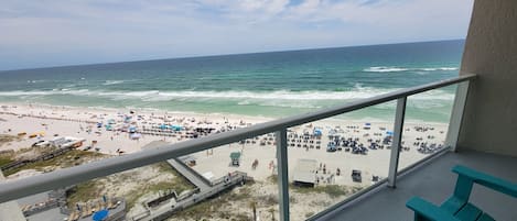 A balcony with a view of a beach and ocean.