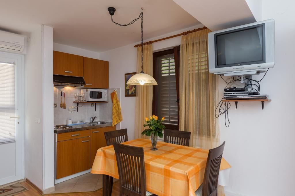 Une cuisine compacte dotée de meubles en bois, d’un four à micro-ondes et d’un coin repas avec une table et des chaises.