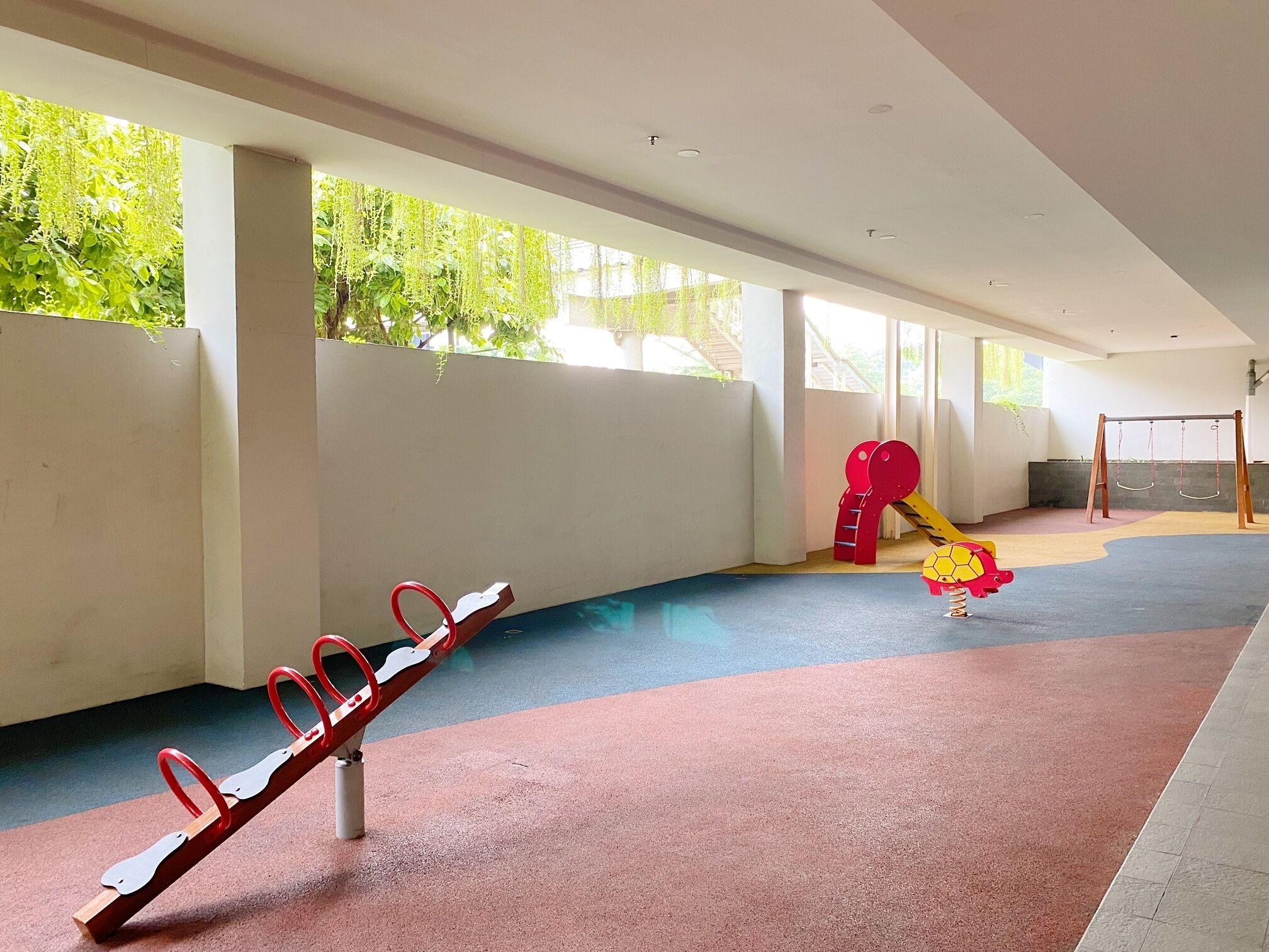 Un espace de jeux pour enfants avec une balançoire, un toboggan et un ensemble de jeux à bascule.