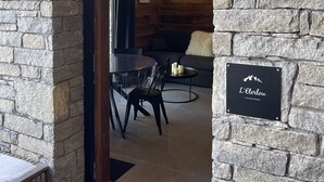 Una entrada de pared de piedra que conduce a un comedor con mesa y sillas.