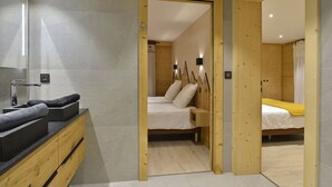 Ein modernes Badezimmer mit einem großen Spiegel, einem Holzwaschtisch und einem integrierten Spülbecken.