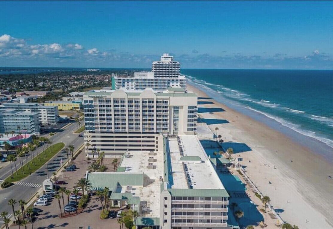 Un hôtel situé en bord de mer, composé de plusieurs bâtiments, doté d’un parking et donnant accès à une plage.