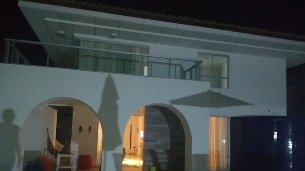 Un bâtiment moderne à deux étages, dot é d’un balcon et de portes en arc de cercle.