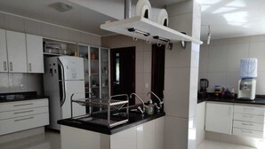 Una cocina moderna con muebles blancos, una isla central con lavamanos y un horno empotrado.