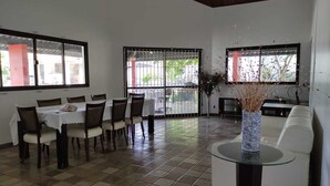 Una habitación amplia con zona de comedor, un sofá y una mesa de centro de vidrio.