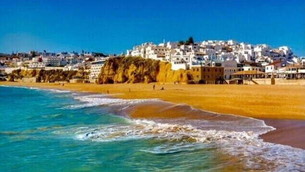 A coastal town with white buildings on a hillside overlooking the beach. - Albufeira Beach Apartment with sea views of the Bay all the way to the Old Town (Albufeira)