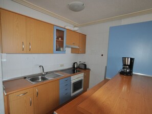 Een koelkast, een oven, een kookplaat, een koffiezetapparaat/waterkoker