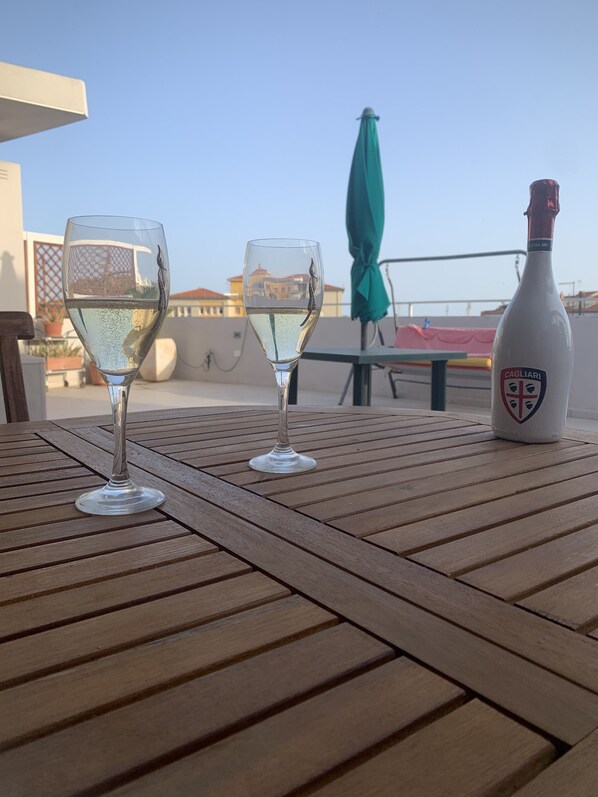 Two wine glasses on a wooden table with a bottle of Cagliari wine.