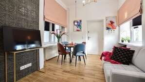 Un soggiorno moderno con televisione, zona pranzo e divano.