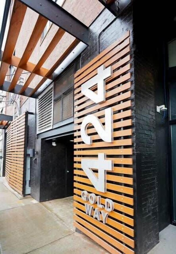 A building facade with a large, bold sign reading "4 GOLD WAY" and a black door to the right.