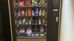 Een automaat met verschillende snacks en drankjes.