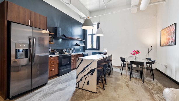 A modern kitchen with a large island, stainless steel appliances, and a dining area with bar stools. - Spacious Loft 2 bedroom in N Oakland 400, sleeps 8 (Pittsburgh)