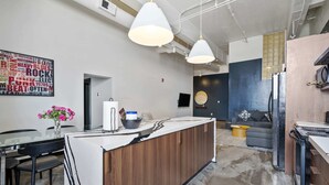 A modern kitchen with a central island, pendant lighting, and a word cloud mural on the wall. - Spacious Loft 2 bedroom in N Oakland 400, sleeps 8 (Pittsburgh)