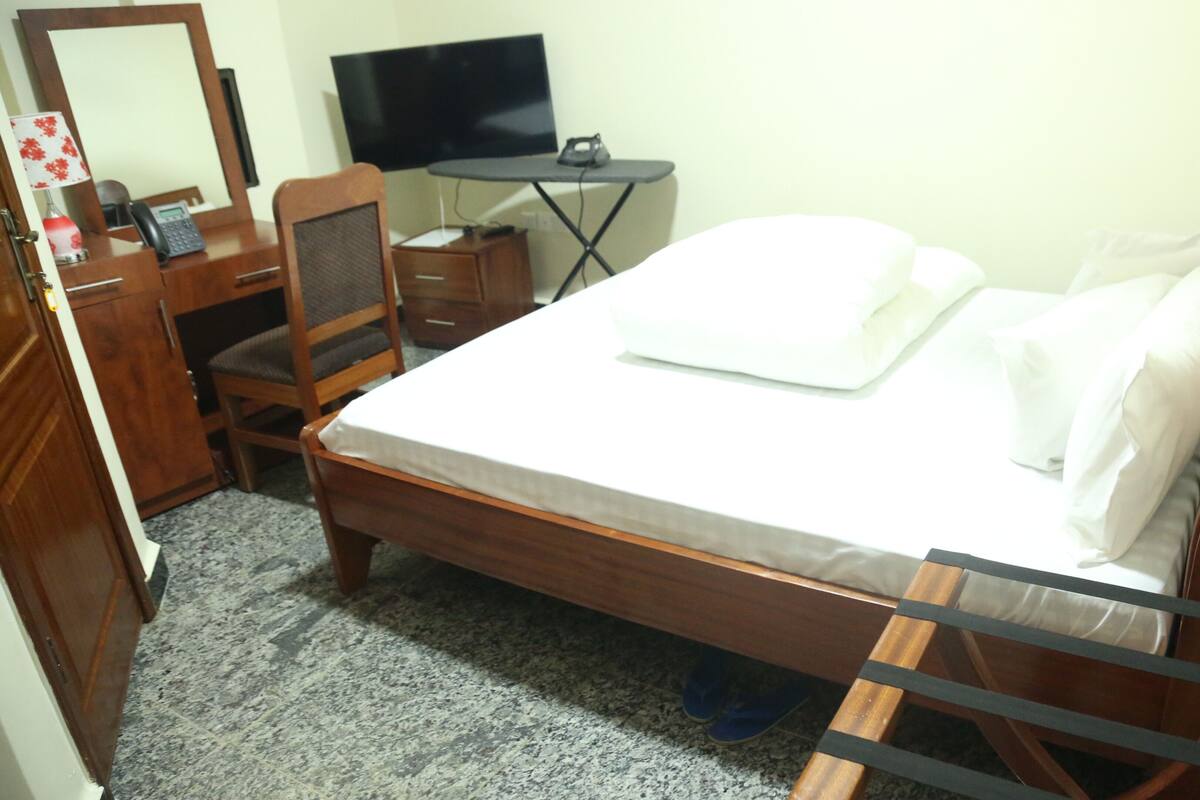 Escritorio, cortinas blackout y tabla de planchar con plancha