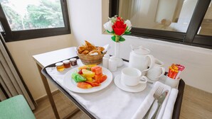 Ontbijt met croissants, fruit en koffie op een dienblad.
