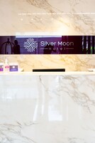 A reception desk at the Silver Moon Hotel with a marble countertop and a logo above it.