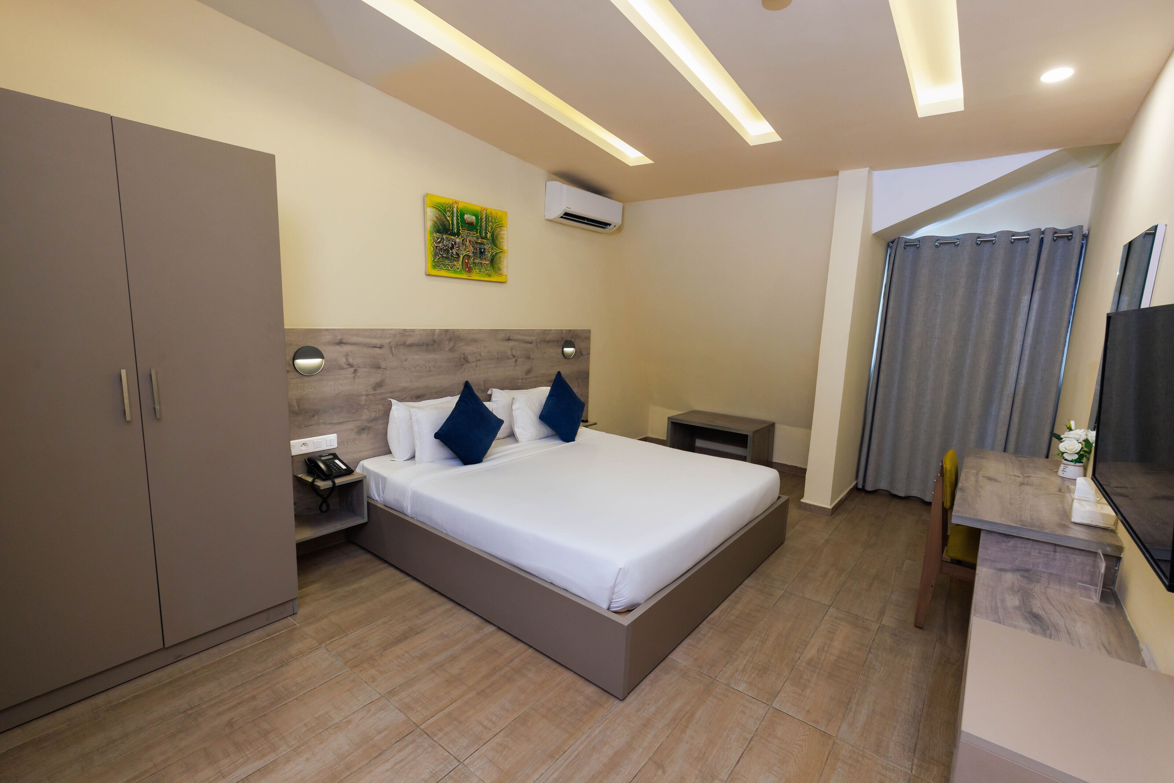 Una camera d'hotel moderna con un letto grande, una scrivania, un armadio e un tavolino.