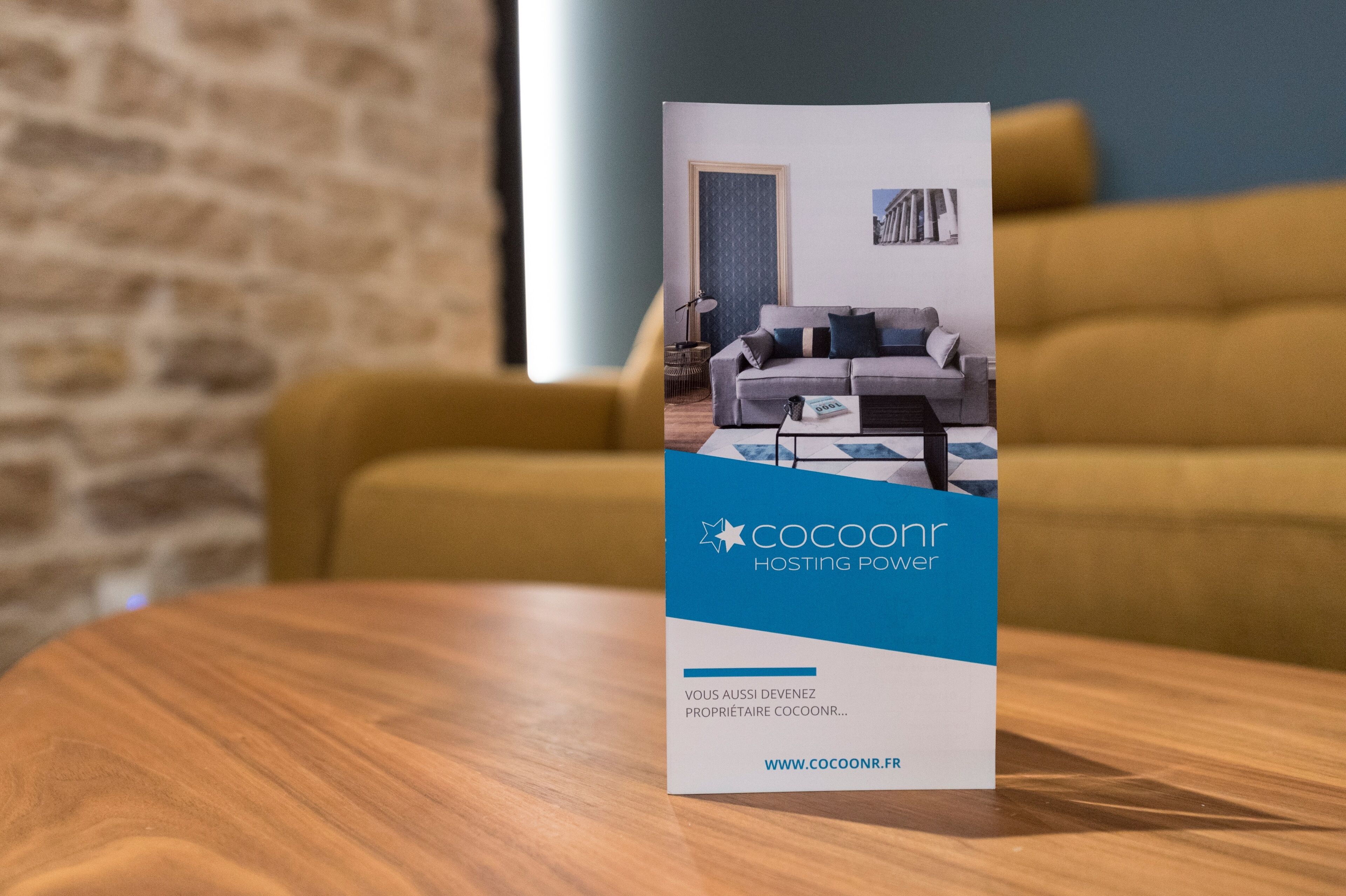 A brochure for cocoonr hosting power, featuring a modern living room with a sofa and a coffee table.