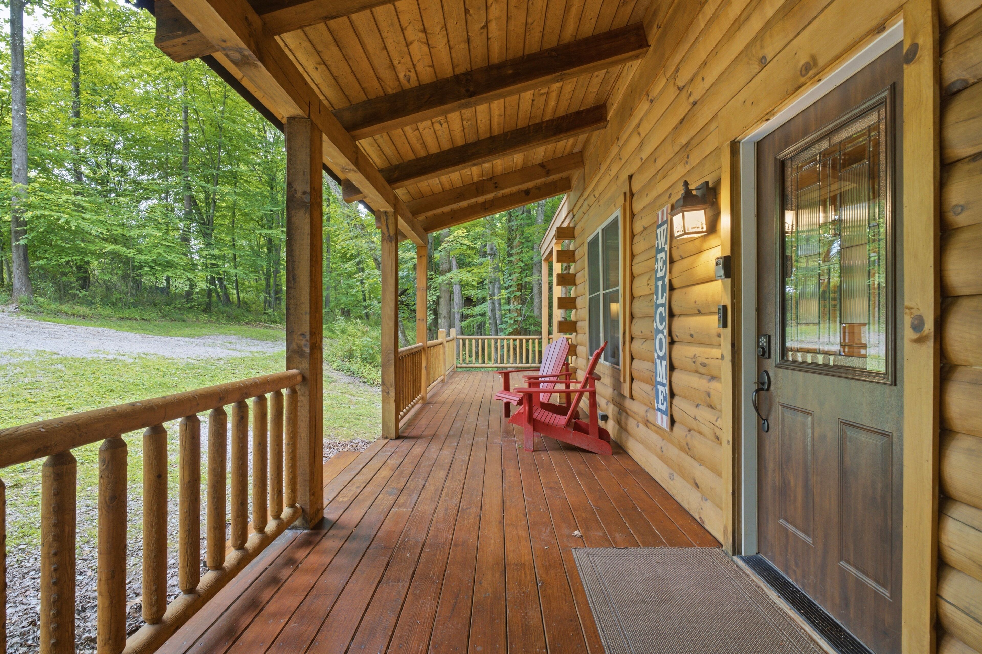 A wooden cabin with a porch, a door, and a window with a welcome sign.