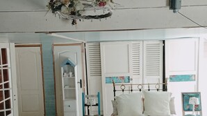 A bedroom with a bed, a chair, a wardrobe, and a hanging light fixture. - A warm, 100% eco-responsible hotel to recharge your batteries (Morsains)