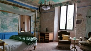 A room with a four-poster bed, a wooden desk, a chair, and a chandelier. - A warm, 100% eco-responsible hotel to recharge your batteries (Morsains)