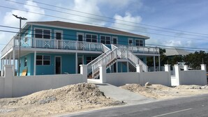 A two-story house with a balcony, a staircase, and a driveway.