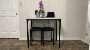 A small kitchen area with a white countertop, two black bar stools, a coffee maker, a jar, and a purple orchid. - National parks and nice place to relax (Tulare)