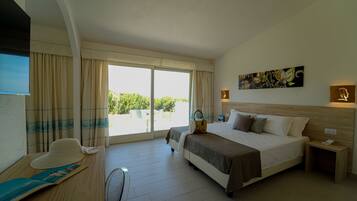 A hotel room with a large bed, a desk with a chair, a window with curtains, and a painting on the wall.