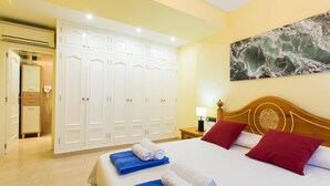 A hotel room with a large bed, a wardrobe, and a painting on the wall. - 5 minutes from the beach! Ideal house for families, with private pool. (La Xara)