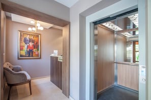 A reception area with a framed family photo, a reception desk, and an elevator.