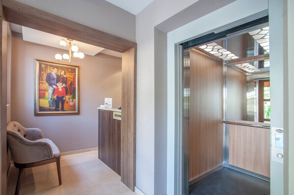 A reception area with a framed family photo, a reception desk, and an elevator.