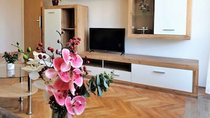 Una sala de estar moderna con un mueble de madera para entretenimiento, un televisor de pantalla plana y un espejo grande.