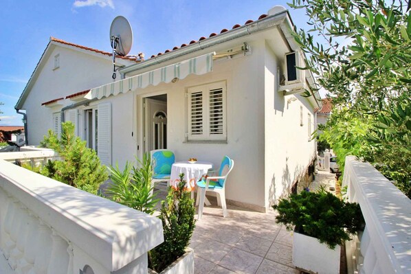 Traditional Mediterranean-style building with a small patio area and potted plants.