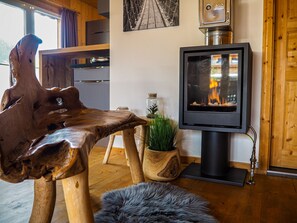 A cozy room with a wooden table, a television, and a fireplace. - Murau 18 - Chalet with whirlpool & infrared sauna (Murau)
